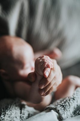 père tenant le pied d'un bébé